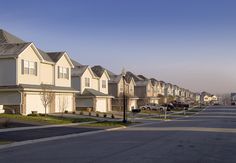 a row of houses with cars parked on the street