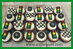 cupcakes are arranged in the shape of cars and checkered flags on display