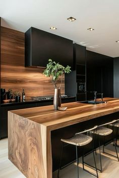 a kitchen with black cabinets and wooden counter tops, along with stools that match the wood flooring