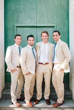 three men in suits and ties are posing for a photo outside the door of a building