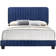 a bed with blue upholstered headboard and two pillows on top of it