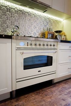 a kitchen with an oven, stove and counter tops in white cupboards on the wall