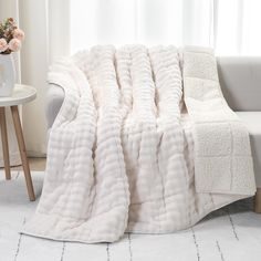 a large white blanket sitting on top of a couch