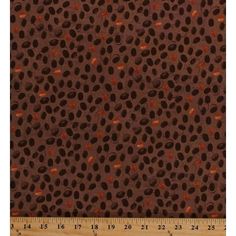 an animal print fabric in brown and black with orange spots on the bottom, along with a ruler