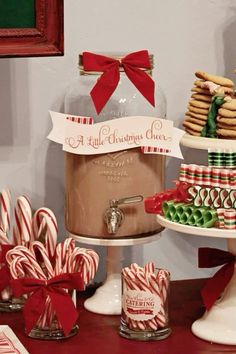 a table topped with lots of candy canes next to a jar filled with cookies