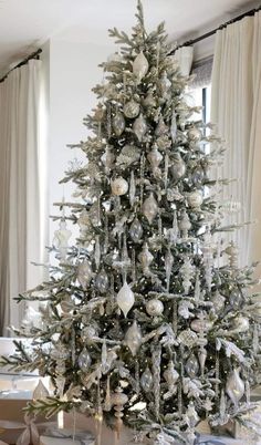 a white christmas tree with silver ornaments