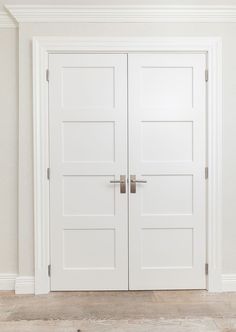 an empty room with two white double doors