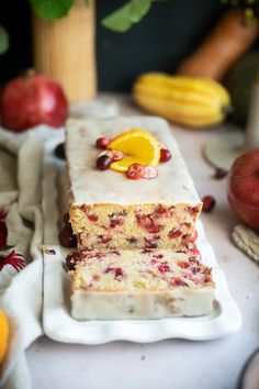 two slices of cake sitting on top of a white plate next to oranges and apples