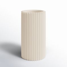 a white vase sitting on top of a table