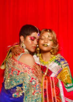 two women dressed in colorful clothing hugging each other