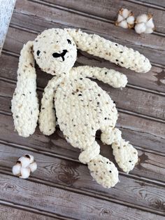 a crocheted stuffed animal sitting on top of a wooden floor next to garlic