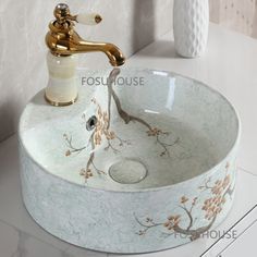 a bathroom sink with an artistic design and gold faucet on the counter top