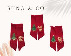 three red neck ties with gold monogramming and christmas tree on them, sitting next to each other