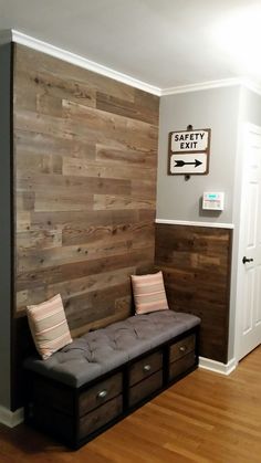 a bench sitting in front of a wall with wooden planks on it's sides