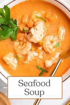 a bowl of seafood soup with a spoon in it and the words seafood soup above it