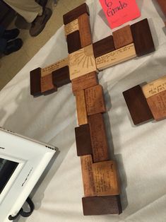 a wooden cross sitting on top of a table next to a white framed photo frame