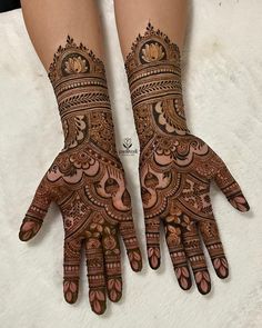 two hands with henna designs on them