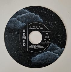 a black and white record with the word columbia on it's disc cover, against a background of dark clouds