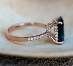 a close up of a ring with a stone in the middle and diamonds around it