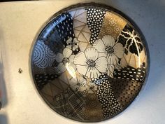 a black and white plate with flowers on it sitting on top of a countertop