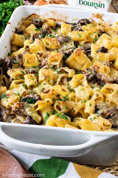 a casserole dish filled with pasta, mushrooms and parsley in a white baking dish