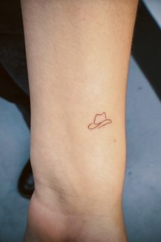 a small hat tattoo on the ankle