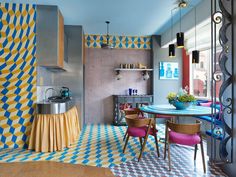 a colorful kitchen with blue and yellow tiles on the floor, white walls and ceiling