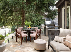 an outdoor kitchen and dining area with grill, table, chairs, and couches