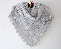 a white crocheted shawl hanging on a wall