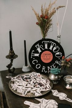 a table topped with plates and vases filled with dried flowers on top of a wooden table