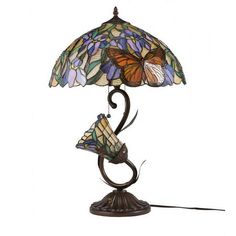 a lamp that is sitting on top of a table with a butterfly design on it