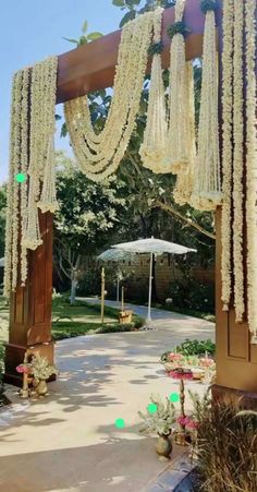 an outdoor ceremony with white flowers and hanging decorations