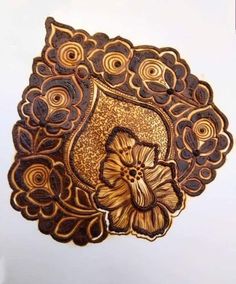 an intricately designed wooden brooch with flowers on it