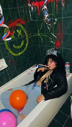 a woman sitting in a bathtub with balloons