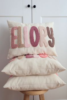 three pillows stacked on top of each other with the word pillow spelled out in large letters