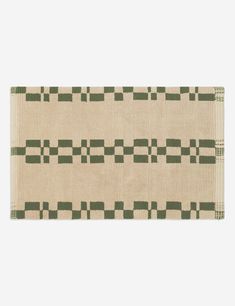 a beige and green rug with checkered design on the bottom, in front of a white background