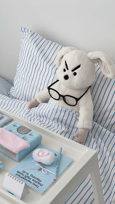 a stuffed dog wearing glasses on top of a bed