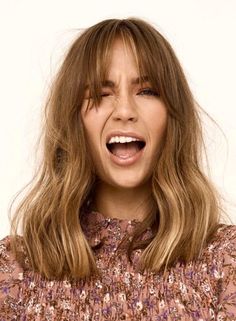 a close up of a person with long hair and a surprised look on their face