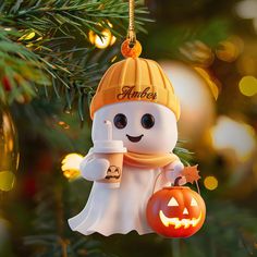 a christmas tree ornament with a ghost holding a cup and a jack - o'- lantern