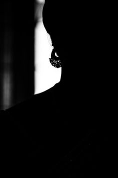 the silhouette of a woman with large earrings