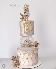 a three tiered cake with an angel figurine on top and clock decorations