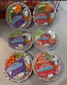 six plastic bowls filled with assorted fruits and veggies on a counter top