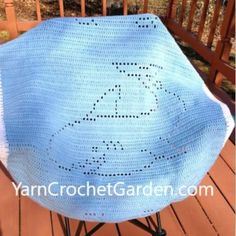 a blue crocheted blanket sitting on top of a chair