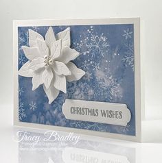 a blue and white christmas card with a poinsetti flower on it's side