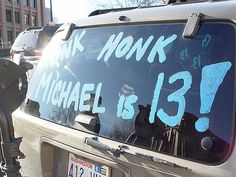 the back window of a parked car with graffiti on it that reads ask honk michael is 13