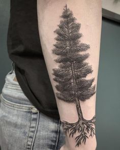 a man's arm with a tree tattoo on it