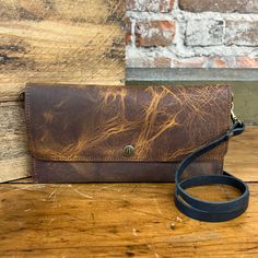 The Carly Clutch can be worn 5 ways - as a crossbody bag, a fanny pack, bum-bag, wallet or as a wristlet clutch. This small purse has a built-in wallet, with 3 card slots. The zippered pocket on the back will keep your small goods secure! 4.5" x 9" Single snap closure Removable 48" adjustable strap Removable wristlet One exterior zipper pocket Handcrafted in our workshop in Chariton, Iowa – USA Due to the resolution of your mobile and computer screens, actual color may vary. Our leather is premi Classic Clutch With Cell Phone Pocket For Everyday Use, Brown Crossbody Wallet, On-the-go Brown Crossbody Wallet, Brown Crossbody Wallet For On-the-go, Brown Wallet With Removable Pouch Crossbody, Everyday Rectangular Wallet On Chain, Travel Wallet With Detachable Strap And Crossbody Shape, Travel Wallet On Chain With Phone Bag, Classic Crossbody Wallet With Removable Pouch