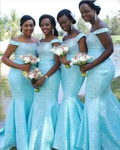 three women in blue dresses standing next to each other with flowers on their bouquets