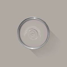 a can of paint with a long shadow on the wall in front of it's lid