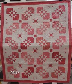 a red and white quilt hanging on a rack